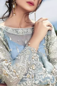 Intricate details, flamboyant silhouettes and mastery of colour are what makes this dress stand out from the rest. This is one of the elegant pieces are sure to stay in your heart and your wardrobe forever. The front of the shirt is beautifully ornamented with floral motifs and bootis, also a delicate arrangement of geometric patterns on the hemline with light golden and silver zardozi work. The back of the shirt is accentuated with a large central motif and scattered tiny floral motifs all over. It comprises with ferozi capri pants emphasized with bottom. To complete the look, go with a gradient dupatta having geometric patterns on pallu and scalloped border along the length. Furthermore the outfit is fully decorated with scalloped finishing and tassels.