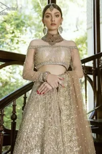 This outfit brings drama and playfulness to traditional lehenga blouse with a modern approach. Classic balanced pattern on the lehenga of tissue fabric adds exquisiteness to the look. The selection of color much of a choice for the festive season. The off shoulder blouse make a statement with light golden zardozi work. Complete the look with golden dupatta heavily embellished from all four sides and sprinkled with sequins all over.