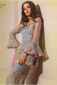 Embrace the season of festivities with this beautiful dress. The chic yet elegant outfit is decorated with golden embroidery, embellished neckline and tiny floral motifs. Borders are even more enhanced with golden zardozi detailed patterns and finished with scallops and dangling balls. Pair it up with gray sharara highlighted with floral jaal and scalloped bottom done with golden kora, dabka and tilla work. The look is complete with pink net dupatta sprinkled with sequins all over.