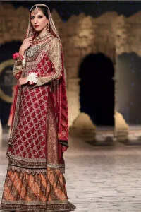 Classic, timeless and truly beautiful, our bridal dress is perfect for your unforgettable day. A perfectly pretty combination of antique and light gold embellishment, this wedding dress is elegant and eye-catching in equal measure. The bodice is crafted artfully with embellished bodice and rest of the shirt is adorned with geometric patterns.  Finished with fine zardozi work on the hemline and decorative. Accompanied by a banarsi chatta patti lehenga enhanced with antique shaded kora, dabka and tilla embroidery. Finish the look with maroon organza dupatta having embroidery on all four sides.