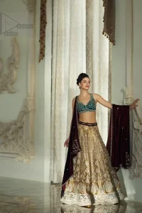 Delicately crafted and personifying chic elegance with an element of grandiose. Gussy up in this luxuriously designed lehenga blouse emboldened with intricate embroidery along with beautiful rich patterns and delicate details at the bottom. The maroon waist belt on lehenga make it so classy. It comprises with teel blouse adorned with tiny floral motifs in the shade of silver. The outfit is pair up with maroon velvet dupatta emphasized with silver and golden zardozi work on all four sides.