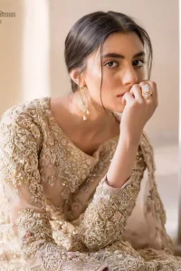 Picturing your bridal in a tea rose colour? This subtleness laden with ornamental embellishments and embroidery creates such a fairytale touch to your wedding. The boat-shaped blouse is emphasized with light golden zardozi work and finished with dangling pearls. Paired up with matching lehenga creates an unusual charisma wholeheartedly. Featuring beautiful handwork and a delicate arrangement of hand-embellished floral patterns with zardozi work along the length of lehenga. Refined craftsmanship is at its best with a hand embellished dupatta. The dupatta incorporates beautifully designed borders on all four sides, focusing on the heavily embellished pallu borders to give it a perfect maharani look.