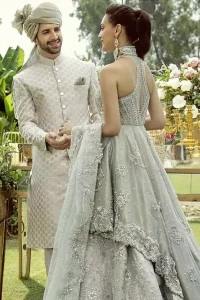 Drape yourself to perfection for the classiest affair in this flattering pastel green ensemble festooned with intricate zardozi hand embroidery work & motifs. The back train peplum is adorned with a halter neckline and beautifully embellished bodice with silver zardozi work. The rest of the peplum is emphasized with a delicate arrangement of hand-embellished floral bunches and scattered sequins spray all over. Accompanied by a matching lehenga decorated with silver zardozi work. Elegance is personified when it gets paired up with a pastel green dupatta having chann and applique finishing all around the edges.