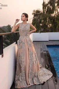 Some brides definitely shine bright by stepping out of the classic box and jumping into pastel hues for their big day. The front open back train dreamy maxi is adorned with an embellished bodice and floral booties all over the body giving a perfect ending to this outfit. The embroidery is done in the shade of silver and gold. Furthermore, the back train is emphasized with a large central motif and thick embellished borders. Coordinated with matching net lehenga and tea rose dupatta having a four-sided scalloped border.