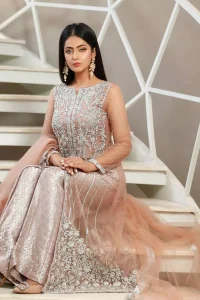 With pure fabric heavily embroidered with zardozi and the perfect blend of traditional flamboyance and modern elegance in design, you need to look no further for the perfect look for any formal occasion. The shirt is delicately crafted with silver zardozi work. The bodice is heavily laden with silver embellishment. Pair it up with tea rose palazzo pants scattered pearls on the bottom edge. The outfit is coordinated with net dupatta having kiran on all four sides.