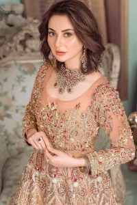 Peach Ruffled Maxi – Back Train Style Dupatta. Peach Blossoming Floral like Maxi with a frilled red border and Organza fabric is a delight to watch worn by the Bride on her Engagement or carried on the Next Day of Reception. With round neckline shape and dense work of red, golden and peach embroidery i.e multi colour conventional tilla, dabka, and Zardozi work with sequins floral motifs and climber networks of beautiful patterns all engraved through embroidery over the whole maxi with large flare and red frilled border glorifying the stitching with complete full sleeves i.e concealed with side zip line and fully embellished body too. Finished edges make the stitching stand out the best with multicolour embroidery. Dupatta has its own grace here with this splendid outfit too in peach colour with net fabric with zardozi work and fully embellished with finished edges and large coverage area with a heavy appearance on (organza) too along with floral motifs. The down below constitution consists of peach raw silk made Churidar Pajama with finished stitching and beautiful appearance making the whole outfit a choice to wear. Hence whole work has dense stitching extra toppings including kora, dabka, stones, sequins, beads, silk threads and Swarovski crystals. Along with 100% pure highest quality imported fabric.