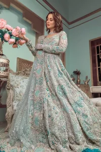 This style-savvy bride totally pulled off our classic bridal wear with unmatchable grace-giving major bridal goals. Featuring beautiful handwork, this outfit has a delicate arrangement of hand-embellished floral patterns with pearls and crystals along the length. Refined craftsmanship is at its best with hand embellished zardozi work elegantly all over the outfit. Frilled on the bottom of the maxi makes the outfit look like nothing but a dream. This outfit is paired with an organza dupatta with embroidered border and raw silk churidar pajama, making it a statement piece.