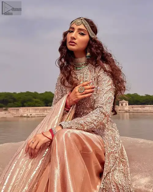 the dress with a tissue dupatta and graceful palazzo pants makes you the center of attention on your big day. Peach