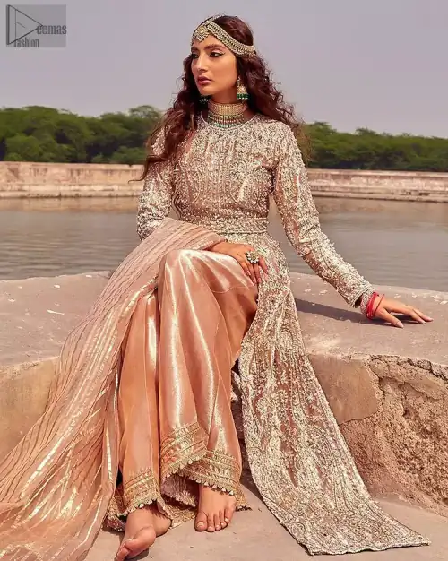 the dress with a tissue dupatta and graceful palazzo pants makes you the center of attention on your big day. Peach