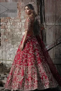 Envelop yourself into the dazzling love affair. Surprise everyone with this deep red article on your Big day. Stating this article with a deep red blouse that is handsomely styled with boat shape neckline. The half sleeves of the blouse just boost the attractiveness of the design.  In addition to this, it is delightfully furnished with golden embroidery which includes kora, dabka and tilla. Brace the blouse with a deep red fluffy lehenga that is again heavily embellished with golden embroidery that increases the beauty of the article. Complete this article with the same colour dupatta which is embellished with a four-sided borders and sequins sprayed all over just to envelop you into the dazzling love affair on your big day. 
