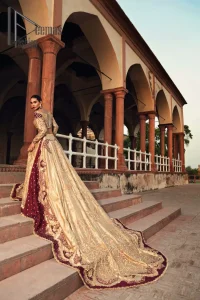 Adorn yourself in the layers of golden that feel rich on the skin. This outfit which is starting with a blouse beautifully laden with golden embroidery that includes kora, dabka, tilla to give you a traditional bride look. It is highlighted with boat shape neckline and super aesthetic full-sleeves to enhance your emotion of you on your Big Day. It is systematically arranged with a two-tone lehenga which is prominent with back train style and heavily adorned with embroidery. Finish this article with a golden scalloped dupatta that is embellished with four-sided borders and sequins sprayed all over. 