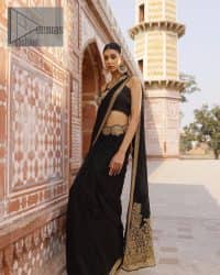 Every saree tells a story! Black is always the reason behind any smile at parties. DeemasFashion also presents a formal saree in black that you can wear at any function or party. The black blouse having sleeveless and strap neckline gives you so soothing and romantic look. Further, the simplicity of the blouse enhances the beauty of the outfit. It comes with a pure black saree which is ornamented with golden embroidery. It is highlighted with tilla, kora, and dabka work on borders. The pallu of the saree is also prominent with golden embridery.
