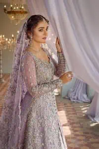 Bold instruments on a bright canvas make a true fashion statement. Introducing a lilac outfit for your Walima day to boost up your day. The front open gown in lilac colour looks as amazing as any bride's dream. It is encapsulated with silver embroidery which contains crystal, tilla, dabka, kora and sequins spray all over. In addition to this, it is highlighted with a sweetheart neckline to enhance the beauty of the gown when combined with full sleeves. It is systemized with silver barcode sharara finished with silver border embroidery that enhances the look of the bride during the day as well as night events. Complete this lilac article with a dupatta which is ornamented with four-sided borders and sequins sprayed all over. 