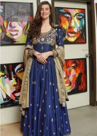 Hues of blues make a funky yet amazing pattern on amazing events. DeemasFashion introduces a navy blue outfit. Starting this article with a navy blue multiple panel frock which is ornamented with golden embroidery. The pattern of embroidery begins with the round neckline which is handsomely embellished with tilla, dabka, kora and Kundan. It is further prominent with full sleeves. The rest of the frock is decorated with floral motifs in a golden hue. The following frock comes with a golden dupatta to complete the admiring look on any day or night event.