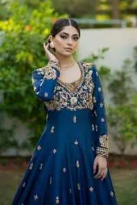 Hues of blues make a funky yet amazing pattern on amazing events. DeemasFashion introduces a navy blue outfit. Starting this article with a navy blue multiple panel frock which is ornamented with golden embroidery. The pattern of embroidery begins with the round neckline which is handsomely embellished with tilla, dabka, kora and Kundan. It is further prominent with full sleeves. The rest of the frock is decorated with floral motifs in a golden hue. The following frock comes with a golden dupatta to complete the admiring look on any day or night event.