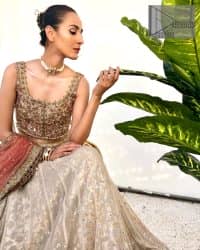 The perfect outfit for walima to enhance your glow. Starting this article with a dream rust blouse having a strap neckline and prominent sleeveless style to embrace the romantic culture. The following blouse is fully embellished with golden embroidery that is prominent with tilla, dabka, kora, pearls and sequins spray to fulfil your dreamy look. It is coordinated with an ivory can-can lehenga whose border is again rendered with golden embroidery and sequins sprayed all over to continue the look. Complete this outfit with a rust dupatta which is embellished with four-sided borders and sequins sprayed all over to enhance the glow of the bride.