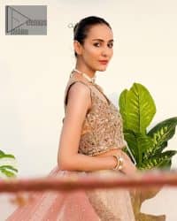 The perfect outfit for walima to enhance your glow. Starting this article with a dream rust blouse having a strap neckline and prominent sleeveless style to embrace the romantic culture. The following blouse is fully embellished with golden embroidery that is prominent with tilla, dabka, kora, pearls and sequins spray to fulfil your dreamy look. It is coordinated with an ivory can-can lehenga whose border is again rendered with golden embroidery and sequins sprayed all over to continue the look. Complete this outfit with a rust dupatta which is embellished with four-sided borders and sequins sprayed all over to enhance the glow of the bride.