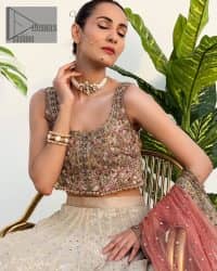 The perfect outfit for walima to enhance your glow. Starting this article with a dream rust blouse having a strap neckline and prominent sleeveless style to embrace the romantic culture. The following blouse is fully embellished with golden embroidery that is prominent with tilla, dabka, kora, pearls and sequins spray to fulfil your dreamy look. It is coordinated with an ivory can-can lehenga whose border is again rendered with golden embroidery and sequins sprayed all over to continue the look. Complete this outfit with a rust dupatta which is embellished with four-sided borders and sequins sprayed all over to enhance the glow of the bride.