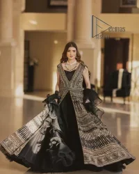 Wear black in-depth to lead colourful lives. DeemasFashion presents black party wear which includes a front open maxi having light golden embroidery which is beautifully decorated with tilla, dabka, kora and Kundan. Further, it is prominent with sleeveless style and sweetheart neckline to make you a memorable girl of the event. The part wear is organized with a frilled lehenga which is a unique core piece. Complete this party wear with a dupatta in the same colour to boost your day with black.