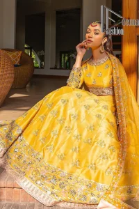 Yellow is just associated with mehndi as the sun is associated with brightness. DeemsFashion presents the bright yellow Pakistani mehndi outfit which laboriously begins with a blouse which is handsomely hand-rendered with silver and copper embroidery to make your day super duper bright. The boat shape neckline and full sleeves of this Pakistani mehndi outfit add to the breathtaking dream of the bride. It is paired up with a lehenga in the same colours which is adorned with floral motifs and bordered embroidery as well. Complete this Pakistani mehndi outfit with a dupatta in the same colour which is adorned with a four-sided embellished border and sequins sprayed all over.