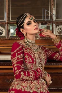 Happiness and confidence are the prettiest things that are associated with your wedding outfit. DeemasFashion presents this Pakistani reception wear in deep red colour. The deep red heavy maxi of this Pakistani reception wear is gorgeously adorned with a golden embroidery which is further enhanced with tilla, dabka, and kora. The boat shape neckline speaks of the boldness of the outfit. The following maxi is paired up with maroon sharara whose border is also embellished. Out and out of this Pakistani reception wears a dupatta in the same colour which is adorned with a four-sided border. Further, it is decorated with sequins sprayed all over.