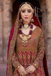 Happy is the bride the maroon shines on. Initiate this Pakistani reception outfit with a maroon heavy Anarkali which is sumptuously hand-rendered with golden embroidery that includes tilla, dabka, kora and Kundan. The V shape neckline of this Pakistani reception outfit exquisitely comes with full sleeves. It is paired up with rust farshi lehenga whose border is again adorned with golden embroidery. Finish this Pakistani reception outfit with a dupatta with a four-sided embellished border and sequins sprayed all over to put a maroonish shine on your big day.