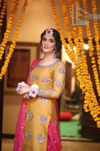 We seek outside the wonders we carry inside us. A mehndi dress in the mustard shirt is enhanced with gorgeous gota work. and is designed using the floral technique in pink and golden which is incrusted with tilla, dabka, kora and Sitara. The border of the mustard shirt is heavily ornamented with golden embroidery. The round neckline enhances the beauty of this mehndi dress when comes with three-quarter sleeves. It is paired up with mustard Gharara which is super simple and its border is encapsulated with Kiran. Complete this mehndi dress with a pink dupatta having ting floral motifs all over.