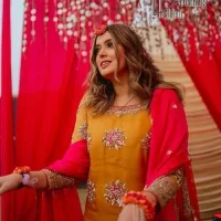 We seek outside the wonders we carry inside us. A mehndi dress in the mustard shirt is enhanced with gorgeous gota work. and is designed using the floral technique in pink and golden which is incrusted with tilla, dabka, kora and Sitara. The border of the mustard shirt is heavily ornamented with golden embroidery. The round neckline enhances the beauty of this mehndi dress when comes with three-quarter sleeves. It is paired up with mustard Gharara which is super simple and its border is encapsulated with Kiran. Complete this mehndi dress with a pink dupatta having ting floral motifs all over.