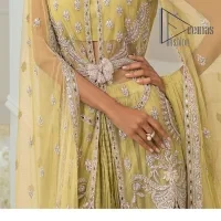 The love we share will make her mehndi day super duper amazing. This mehndi wears an olive front open shirt which is laboriously hand-rendered with a silver embroidery involving tilla, dabka, kora and Sitara. Further, the sweetheart shape neckline fulfils the dreamy look of the bride when comes with cape sleeves. The following shirt of mehndi wear is systemized with crushed sharara which is so simple and unique. Finishing this mehndi wear with a pleated dupatta that is maintaining a balance between outfits.