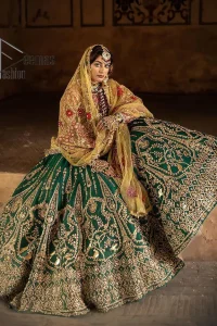 The blushing moment you found your dream mehndi outfit. This mehndi outfit is handsomely and attractively prepared in the level of contrast. Starting this mehndi outfit with a red blouse which is laboriously hand-rendered with light golden embroidery having tilla, kora, dabka and zardozi. In addition to this, it is enhanced with full sleeves and boat shape neckline to make your day super blush. The mehndi outfit is coordinated with a bottle green lehenga which is heavily ornamented with golden embroidery. Complete this article with a golden dupatta having Kiran on all sides. 