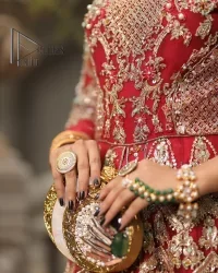 Marry someone who makes your heart shine. Wear what makes your soul shine. Introducing this Pakistani reception outfit which begins with a red blouse which is laboriously hand-rendered with silver embroidery to make your day super bright as silver colour. Further, it is highlighted with tilla, dabka, kora and crystal. The blouse of this Pakistani reception outfit is enhanced with boat shape neckline and three-quarter sleeves. The following blouse of the Pakistani reception outfit is systemized with a panelled lehenga in the same colour which is again heavily embellished. Complete this outfit with a frilled dupatta which is embellished with two-sided borders and sequins sprayed all over to make you shine.