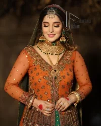 A colourful mehndi outfit is a power which directly influences the soul. Begin this mehndi outfit with a rusted front open shirt which is beautifully decorated with colourful embroidery to give you more power on your mehndi day. It is prominent with tilla, dabka, kora and zardozi. Further, the V shape neckline adds to this mehndi outfit when comes with full sleeves. Paired with a green lehenga having multiple colour borders to give you a more traditional look also. Complete this mehndi outfit with a colourful dupatta which is adorned with four-sided borders and sequins sprayed all over.