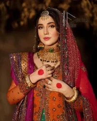 A colourful mehndi outfit is a power which directly influences the soul. Begin this mehndi outfit with a rusted front open shirt which is beautifully decorated with colourful embroidery to give you more power on your mehndi day. It is prominent with tilla, dabka, kora and zardozi. Further, the V shape neckline adds to this mehndi outfit when comes with full sleeves. Paired with a green lehenga having multiple colour borders to give you a more traditional look also. Complete this mehndi outfit with a colourful dupatta which is adorned with four-sided borders and sequins sprayed all over.