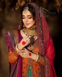 A colourful mehndi outfit is a power which directly influences the soul. Begin this mehndi outfit with a rusted front open shirt which is beautifully decorated with colourful embroidery to give you more power on your mehndi day. It is prominent with tilla, dabka, kora and zardozi. Further, the V shape neckline adds to this mehndi outfit when comes with full sleeves. Paired with a green lehenga having multiple colour borders to give you a more traditional look also. Complete this mehndi outfit with a colourful dupatta which is adorned with four-sided borders and sequins sprayed all over.