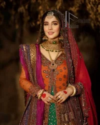 A colourful mehndi outfit is a power which directly influences the soul. Begin this mehndi outfit with a rusted front open shirt which is beautifully decorated with colourful embroidery to give you more power on your mehndi day. It is prominent with tilla, dabka, kora and zardozi. Further, the V shape neckline adds to this mehndi outfit when comes with full sleeves. Paired with a green lehenga having multiple colour borders to give you a more traditional look also. Complete this mehndi outfit with a colourful dupatta which is adorned with four-sided borders and sequins sprayed all over.
