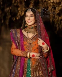 A colourful mehndi outfit is a power which directly influences the soul. Begin this mehndi outfit with a rusted front open shirt which is beautifully decorated with colourful embroidery to give you more power on your mehndi day. It is prominent with tilla, dabka, kora and zardozi. Further, the V shape neckline adds to this mehndi outfit when comes with full sleeves. Paired with a green lehenga having multiple colour borders to give you a more traditional look also. Complete this mehndi outfit with a colourful dupatta which is adorned with four-sided borders and sequins sprayed all over.