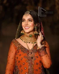 A colourful mehndi outfit is a power which directly influences the soul. Begin this mehndi outfit with a rusted front open shirt which is beautifully decorated with colourful embroidery to give you more power on your mehndi day. It is prominent with tilla, dabka, kora and zardozi. Further, the V shape neckline adds to this mehndi outfit when comes with full sleeves. Paired with a green lehenga having multiple colour borders to give you a more traditional look also. Complete this mehndi outfit with a colourful dupatta which is adorned with four-sided borders and sequins sprayed all over.