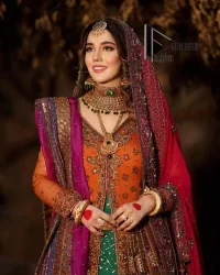 A colourful mehndi outfit is a power which directly influences the soul. Begin this mehndi outfit with a rusted front open shirt which is beautifully decorated with colourful embroidery to give you more power on your mehndi day. It is prominent with tilla, dabka, kora and zardozi. Further, the V shape neckline adds to this mehndi outfit when comes with full sleeves. Paired with a green lehenga having multiple colour borders to give you a more traditional look also. Complete this mehndi outfit with a colourful dupatta which is adorned with four-sided borders and sequins sprayed all over.