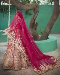 A wine that will make you rise and shine n your Big day. Begin this reception wear with wine red blouse which is beautifully adorned with golden embroidery and further enhance with tilla, dabka, kora and Sitara. The round shape neckline of the blouse meticulously comes with full sleeves. The reception wear also includes the flared lehenga in the same colour which is highlighted with multiple colour embroidery as well. In parallel to this, the dupatta in the same colour is heavily adorned with four-sided borders and floral motifs all over to make you rise and shine in this reception wear.