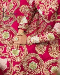 A wine that will make you rise and shine n your Big day. Begin this reception wear with wine red blouse which is beautifully adorned with golden embroidery and further enhance with tilla, dabka, kora and Sitara. The round shape neckline of the blouse meticulously comes with full sleeves. The reception wear also includes the flared lehenga in the same colour which is highlighted with multiple colour embroidery as well. In parallel to this, the dupatta in the same colour is heavily adorned with four-sided borders and floral motifs all over to make you rise and shine in this reception wear.