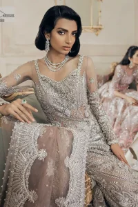 Luxurious canvas embodying grace and style! It is a well-crafted short shirt enhanced with silver embroidery accentuated with gleaming ornaments. The following shirt is incrusted with tilla, dabka, kora, zardozi and beautiful detailing of crystal. Further, it is coordinated with a back train lehenga which is meticulously adorned with heavy embroidery to make you the real dreamy fairy. Complete this Walima article with a dupatta in the same colour, framed with a four-sided border. The tiny floral motifs and sequins sprayed spread all over on the dupatta for memorable grace.