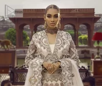 This vibrant canvas is all your brides need to cheer in at your special Nikah moments. A beige white blouse has a V shape neckline and full sleeves embellished with golden and silver embroidery. It is further intensified with special tills, dabka, kora, Kundan and the magic of zardozi to make your day outstanding and more funable. It is paired up with embroidered scalloped lehenga to fulfil the dreamy fairy look of the bride. Complete this article with a scalloped dupatta in the same colour with a four-sided embellished border and sequins sprayed all over to cheer up.