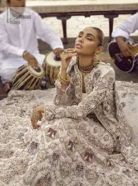 This vibrant canvas is all your brides need to cheer in at your special Nikah moments. A beige white blouse has a V shape neckline and full sleeves embellished with golden and silver embroidery. It is further intensified with special tills, dabka, kora, Kundan and the magic of zardozi to make your day outstanding and more funable. It is paired up with embroidered scalloped lehenga to fulfil the dreamy fairy look of the bride. Complete this article with a scalloped dupatta in the same colour with a four-sided embellished border and sequins sprayed all over to cheer up.