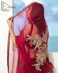 Walking into a new chapter of life with the joy of togetherness and the magic of love. A bright red long shirt is adorned with gorgeous motifs in gold. It is further encrusted with the real magic of tilla, dabka, and kora along with the sequins and pearls. The V shape neckline of this heavy long shirt adds more charm to the outfit when arrives with full sleeves. This beautiful reception piece is paired up with sharara in the same colour with attractive florals that are framed with pearls, Sitara and naqshi that draw the attention of the audience. Complete this article with a dupatta which is adorned with a heavy floral motif to balance the article.