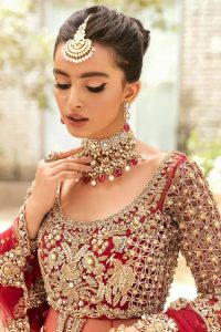 Vibrant outfit to make your reception day more shiny and bright. DeemasFashion presents this maxi in deep red colour, featuring golden embroidery which is enhanced with tilla, dabka, kora, naqshi, zardozi and the magic of Resham. The following scalloped front open maxi has a Round neckline to meet the traditional look when comes with three-quarter sleeves.  In addition to this, it is paired up with a back train lehenga in the same colour framed with embroidery on the border. Complete this article with a scalloped dupatta which is adorned with four-sided borders and sequins sprayed all over for sun-kissed splendour!