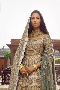 Capturing the essence of modernity on your Nikah with this ivory article. DeemasFashion presents this frock which is intricate with hand embroidery that includes tilla, dabka, kora, Kundan, zardozi and magic of crystal. It is intensified with silver and gold embroidery to make your Qabool Hai moment more delightful and pleasant. Further, the boat shape neckline with three-quarter sleeves strengthens the beauty of the outfit. The following frock is systemized with a lehenga whose border is framed with heavy embroidery. The floral motifs also spread on the lehenga. Complete this outfit with a dupatta in the same colour which is ornamented with four-sided borders and sequins sprayed all over to capture the modern bride.