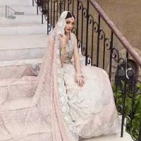 The subtle colour palette, delicate embroidery and eye-catching details. All in all a true style statement! Presenting this light brown maxi which is a luxuriously encrusted masterpiece is laden with tilla, dabka kora, stones,  and delicate Resham. The following front open scalloped maxi is adorned with silver embroidery to make your Nikah day remarkable. The embellished neckline along with the sleeveless style makes you a pretty and unique bride ever. Paired up this article with a sharara whose border is adorned with embroidery. Finish this outfit with a dupatta, framed with four-sided borders and sequins sprayed all over for attractiveness and marvellous details.