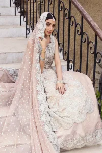 The subtle colour palette, delicate embroidery and eye-catching details. All in all a true style statement! Presenting this light brown maxi which is a luxuriously encrusted masterpiece is laden with tilla, dabka kora, stones,  and delicate Resham. The following front open scalloped maxi is adorned with silver embroidery to make your Nikah day remarkable. The embellished neckline along with the sleeveless style makes you a pretty and unique bride ever. Paired up this article with a sharara whose border is adorned with embroidery. Finish this outfit with a dupatta, framed with four-sided borders and sequins sprayed all over for attractiveness and marvellous details.