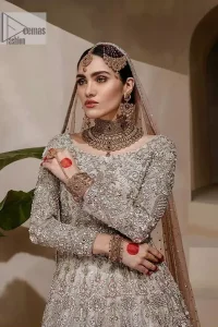 Walk with style on your Nikah day and let the flare follow! This light fawn flare maxi is decorated with tilla, dabka, kora, Kundan and details of Zardozi and enhanced with light golden embroidery for a unique artistic look. Further, the boat shape neckline also intensified the beauty of the outfit when comes with full sleeves. It is coordinated with flare lehenga in the same colour having border embellished to make your day booster day. Complete this outfit with a dupatta, framed with a four sided embellished border and sequins sprayed all over.