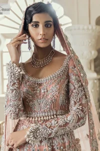 Steal the spotlight at your walima with this light orange yet subtle ensemble! This blouse is in a beautiful shade of orange and is deftly adorned with glowing tilla, dabka and pearls making this ensemble truly ethereal and incandescent. It enhances with the incrusted silver embroidery to make your day. Further, the round neckline of the blouse gives a romantic look when comes with full sleeves. The following blouse is coordinated with a floor-length lehenga which is heavily adorned. The flare of the lehenga adds super beauty to this marvellous masterpiece. Complete this article with a dupatta, framed with a four-sided border and tiny floral motifs all over to steal the spotlight of the show.